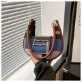 Close-up of a crescent canvas tote bag featuring color-block panels and round leather handles - Blue