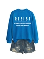 Nahaufnahme von königsblauem Sweatshirt mit RESIST-Aufdruck und zerrissenen Jeans-Shorts - S / Seeblau (Weiße Schrift)