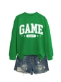 Vue à plat du sweat vert Game Day avec un short en jean bleu délavé et troué - S / Sweat-shirt Vert Herbe (Lettres Blanches)