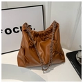 Dettaglio della borsa tote in pelle caramello con design a pieghe e fiocchi eleganti - Marrone