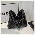 Dettaglio borsa tote nera con tracolla a catena e fiocchi laterali su sfondo bianco - Nero