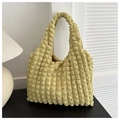 Dettaglio macro del tessuto giallo a trama popcorn su una borsa tote arricciata - Giallo