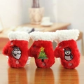 Dettaglio guanti di Natale in peluche rossi con ricami di Babbo Natale su fondo legno - Muffole di Natale
