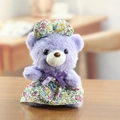 Simpatico orsetto di peluche viola con vestito a fiori e fiocco coordinato sulla testa - Viola