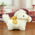 White plush horse keychain with golden ingot and yellow saddle on wooden desk - Beige