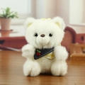 White plush bear keychain with cherry embroidered scarf on a wooden surface - White