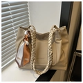 Detalle de bolso beige de piel granulada con asa trenzada y pañuelo de seda decorativo - Caqui