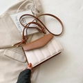 Detailed view of the pleated two-tone leather texture and stylish knotted handle on the bag - Brown