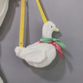 Close-up of plush white duck bag with soft fur texture and adjustable yellow strap - White