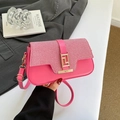 Sac selle magenta chic avec texture tissée et boucle dorée sur un fond gris élégant - Rose