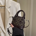 Mini crossbody bag with monogram canvas and brown leather trim in a handheld display - Brown