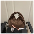 Dettaglio di una borsa leopardata marrone scuro con un design unico del manico a nodo - Marrone