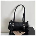 Detail view of black patent leather baguette bag with golden buckles and glossy finish - Black
