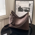 Retro kaffeebraune Hobo-Tasche mit Kontrastnähten und kleinem Beutel auf einem Tisch - Mit kleiner Tasche / Braun