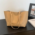 Minimalist khaki leather tote bag with gold lettering shown in a stylish home studio setup - Khaki