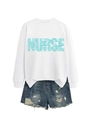 Dettaglio della stampa NURSE su felpa bianca a maniche lunghe con pantaloncini di jeans - S / Bianco