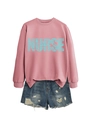 Detail of pink nurse sweatshirt featuring typography design and denim shorts set - Rose Gold