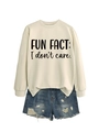 Detailed view of cream sweatshirt with 'FUN FACT: I don't care.' text and denim shorts - Sand Sweatshirt (Black Font)