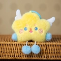 Detail of yellow plush star pendant with blue pom-pom limbs and white wings on rattan - Yellow