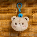 Detalle de llavero de oso de peluche marrón claro con cascabel azul y bordado fino - Tostado