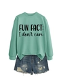 Detail of mint green sweatshirt with 'FUN FACT: I don't care' text and denim shorts - Light Green Sweatshirt (Black Font)