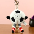 Porte-clés peluche ballon de foot avec visage souriant et longues jambes sur fond rose - Style Football