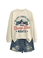 Flat lay of cream sweatshirt with camp fire graphic and ripped denim shorts for outdoor look - Sand