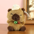 Cute Capybara plush toy with a baseball cap and colorful bells on a wooden desk - Approx. 16cm / Capybara