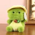 Close-up of green plush dinosaur toy with yellow sun hat and bell on wooden table - Approx. 16cm / Dinosaur