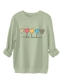 Gros plan sur l'imprimé cœur et texte 'be kind' sur un sweat-shirt vert sauge - Vert olive