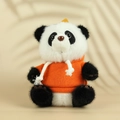 Detail einer Pandapuppe mit leuchtend orangem Hoodie in gemütlicher, warmer Umgebung - Schwarzer Panda Mit Rotem Hoodie