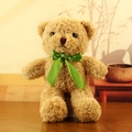 Brown curly plush teddy bear toy with a vibrant green satin bow sitting in a warm setting - Light Brown with Green Ribbon