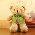 Light brown plush teddy bear toy with a vibrant green silk bow on a wooden surface - Brown with Green Ribbon