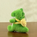 Cute green plush dinosaur keychain with a yellow pineapple backpack accessory on wood - Pineapple Style / 12cm