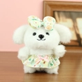 Cute white plush puppy keychain wearing a green floral dress and bow on a wooden desk - Yellow Floral / 13cm