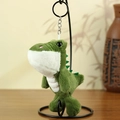 Portachiavi dinosauro in peluche verde con texture morbida appeso a un supporto - verde scuro