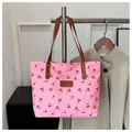 Detail der rosa Tragetasche mit Kirschmuster, braunen Griffen und Leder-Patch - Rosa