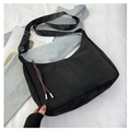 Detail showing the matte black hobo bag with adjustable strap and decorative zipper puller - Black