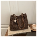 Detailed view of leopard print tote bag with woven handles and fluffy charm ornament - With Pendant / Brown