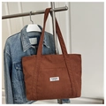 Detalle de bolso tote de pana marrón oscuro con parche de moda y textura de material - Marrón