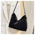 Gros plan d'un sac cabas en daim noir avec sangle décorative à œillets et boucle métallique - Noir