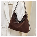 Gros plan sur un sac fourre-tout en daim marron avec bandoulière et boucle en métal - Marron