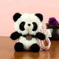 Ciondolo panda di peluche con cinturino rosa e targhetta in legno su tavolo - Panda