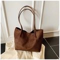 Detail der kaffeebraunen Wildleder-Tote-Bag mit schmalen Riemen auf Tweed-Stoff - Braun