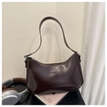 Close-up of a vintage dark brown glossy leather underarm bag with embossed fashion text - Dark Brown