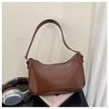 Detail of vintage brown leather crescent bag featuring fashion and bags embossed text - Tan