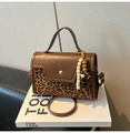 Detalle de bolso con estampado de leopardo sobre libro con colgante y correa ajustable - Leopardo Con Colgante De Perlas De Madera