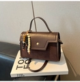 Detalle de bolso de mano vintage marrón con texturas de cuero mixtas y dijes de madera - Café Con Colgante De Perlas De Madera
