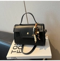 Detalle de bolso de cuero negro con cierre a presión dorado y colgante étnico de cuentas - Negro Con Colgante De Perlas De Madera