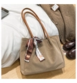 Close-up of khaki tote bag with matte texture and decorative patterned silk scarf detail - Khaki